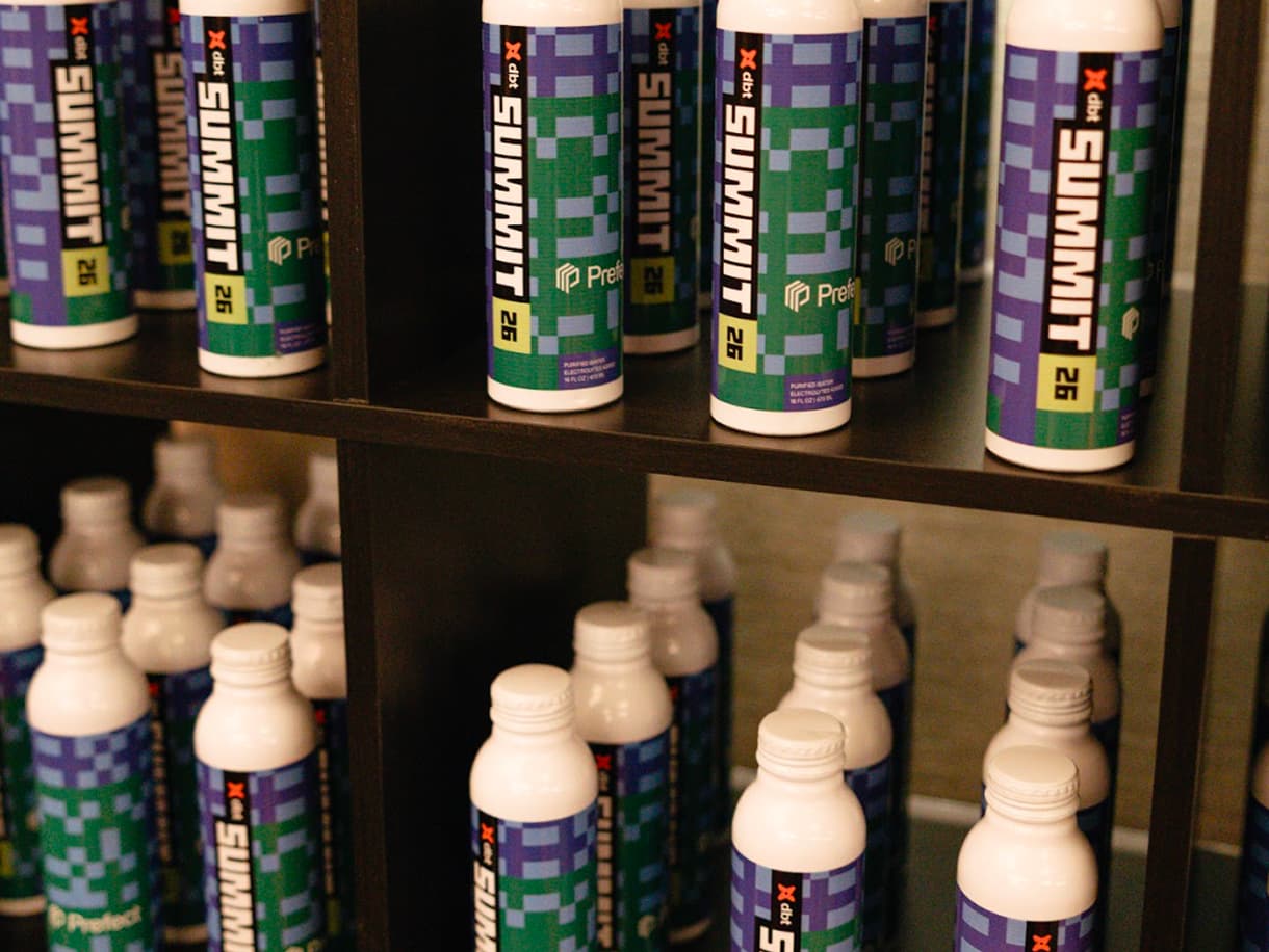 dbt Summit 2026 branded water bottles lined up on the merch shelves